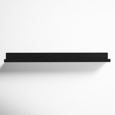 a black shelf is hanging on the wall