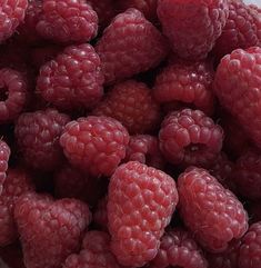 a bowl full of raspberries sitting on top of a table