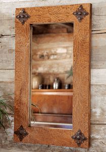 a mirror hanging on the side of a wooden wall next to a potted plant