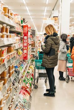 people shopping in a grocery store with carts full of food and drinks on the shelves