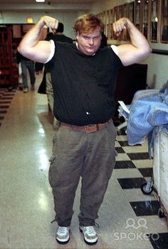 a man standing in the middle of a hallway flexing his muscles with both hands