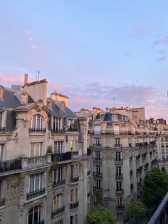 an apartment building with many windows and balconies on the top floor at sunset