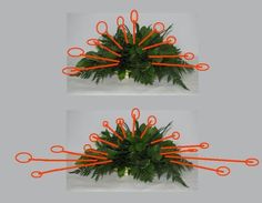 two orange scissors are attached to the top of a christmas tree ornament with green leaves