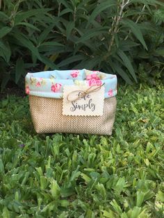 a small purse sitting in the grass with a tag that says love simply on it