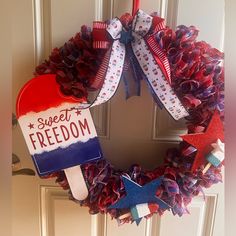 a patriotic wreath with an ice cream popsicle on it and the words sweet freedom written in red white and blue