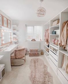 a walk in closet with white shelving and lots of clothes on the shelfs