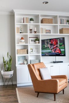 a living room filled with furniture and a flat screen tv mounted on a white wall