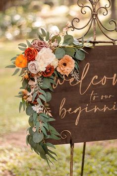 a sign that says welcome to our beginning with flowers and greenery on the front