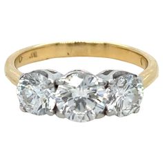 three stone diamond ring in yellow gold with two diamonds on each side and an oval setting