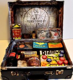 an open suitcase filled with various types of food and drinks on top of a table