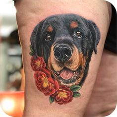 a close up of a person's leg with a dog and flowers on it