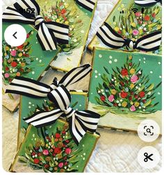 four decorated cookies with black and white ribbons on them, one has a christmas tree