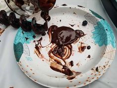 a white plate topped with chocolate sauce and toppings on top of a cloth covered table