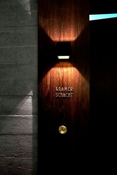 a wooden door with a light on it and the words hammer stacitt written in gold