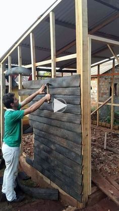 a man standing next to a wooden structure with a circle on the side and another person holding a hammer