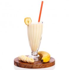 a banana smoothie in a glass with a straw and sliced bananas on the side