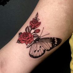 a butterfly and rose tattoo on the arm