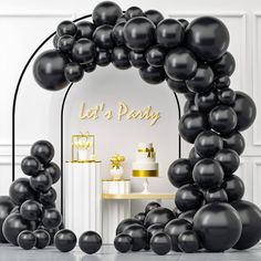 an arch with black balloons in front of it that says let's party on the side