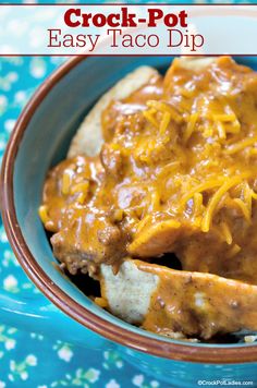 crock - pot easy taco dip in a bowl with bread and cheese on top