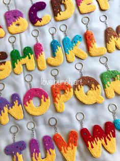 crocheted letters and numbers are displayed on a white sheet with keychains