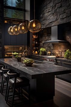 a large kitchen with an island and lights hanging from it's ceiling over the counter