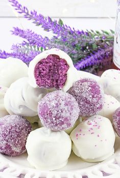 purple and white truffles on a plate with lavender sprinkles next to it