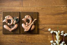 two wooden sculptures sitting on top of a wooden floor