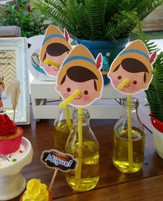 a table topped with bottles filled with liquid and cupcakes