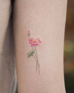 a small pink flower tattoo on the left thigh