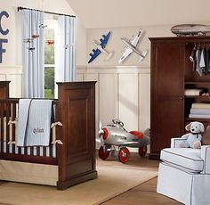 a baby's room with an airplane theme on the wall and other decor items