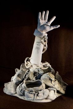 a pile of shoes with a hand reaching out from it