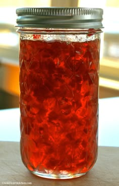 a jar filled with red liquid sitting on top of a table