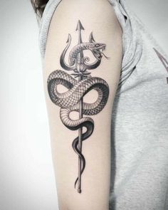 a woman with a tattoo on her arm holding a snake and dagger in the shape of a