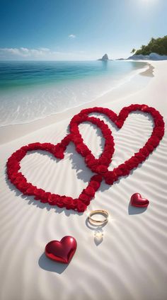 two hearts on the beach with wedding rings