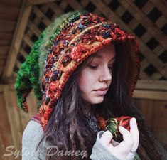 a woman wearing a knitted hat and holding a piece of fruit in her hand