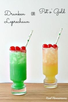 two glasses filled with different colored drinks on top of a wooden table next to each other