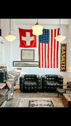 a living room filled with furniture and an american flag hanging on the wall above it