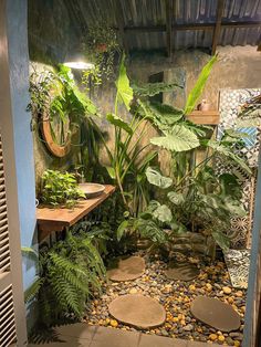 a bathroom with lots of plants and rocks on the floor, along with a sink