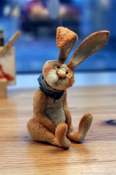 a stuffed rabbit sitting on top of a wooden floor