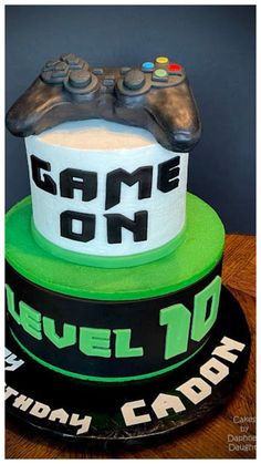 a birthday cake with a video game controller on top and the words level 10 written on it