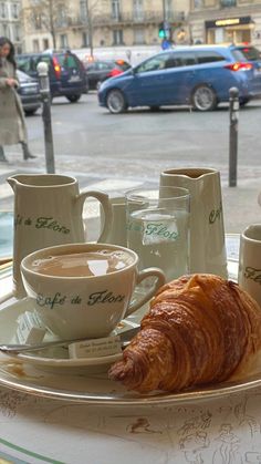 there is a croissant and coffee on the table