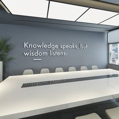 an empty conference room with white chairs and a sign on the wall that says, knowledge speaks, but wisdom listens