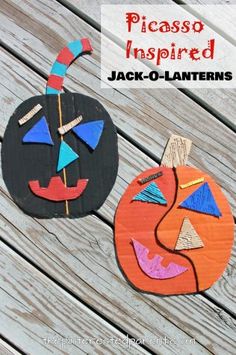 two pumpkins made out of wood sitting on top of a wooden table