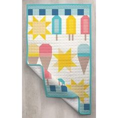 a quilted wall hanging on the side of a wall with stars and ice creams