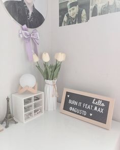 a white desk topped with a vase filled with flowers