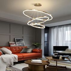 a living room filled with furniture and a round light fixture hanging from the ceiling above it