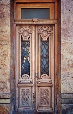 an ornate wooden door with glass panels