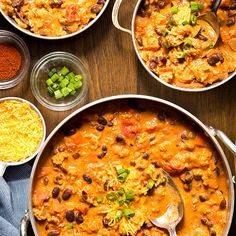 several bowls filled with different types of food on top of a wooden table next to spoons