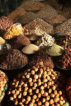 many bowls filled with different kinds of nuts