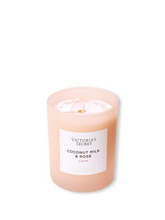 a candle that is sitting on top of a white surface with the words coconut milk and rose